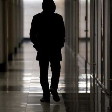 Suspicious person walking in a hallway