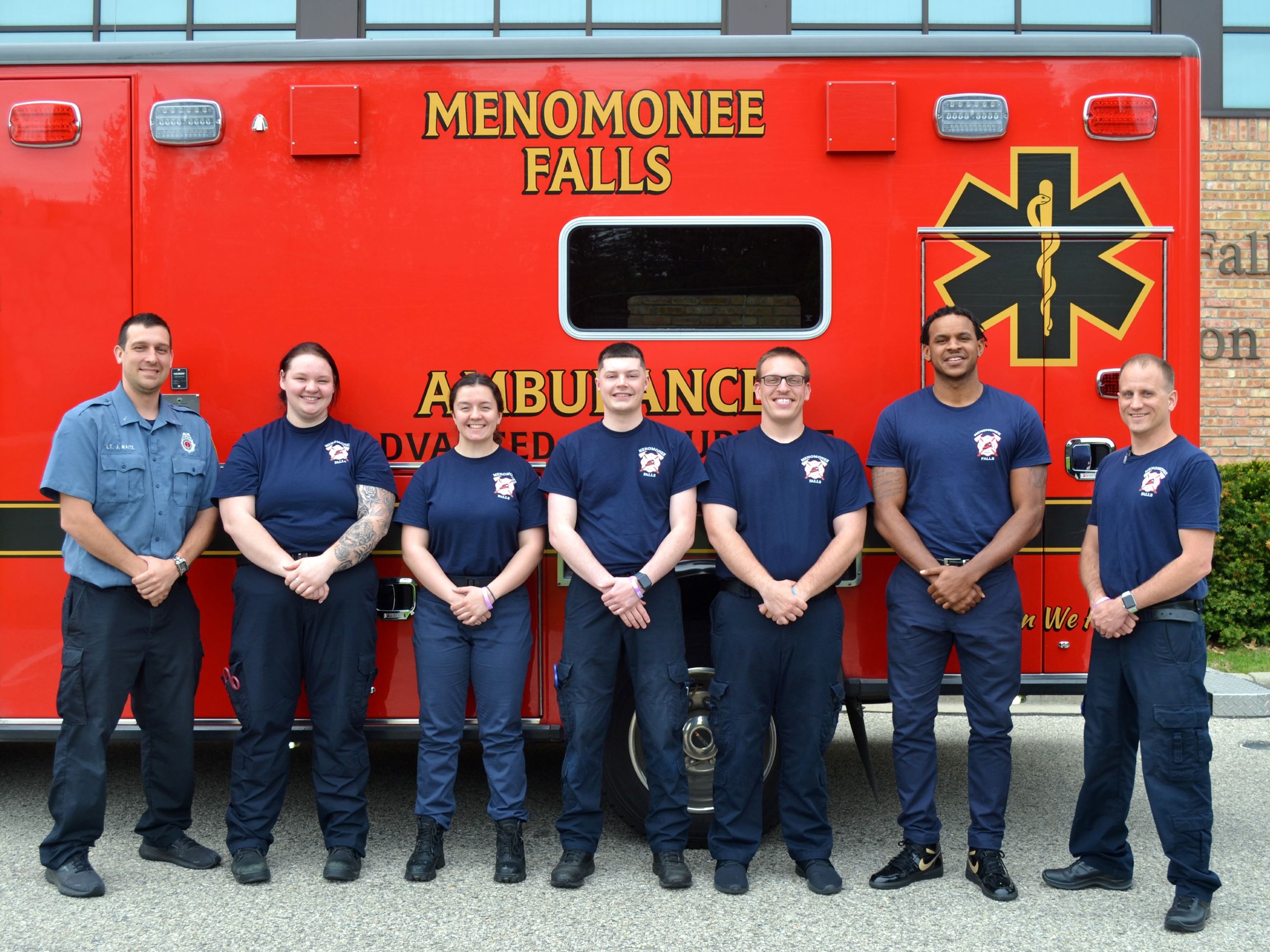 group of firefighters standing by an ambulance